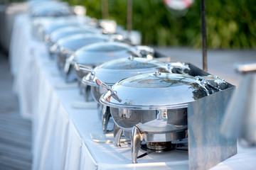 Fototapeta na wymiar Buffet Table with Row of Food Service Steam Pans