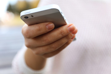 Woman holding smartphone outside