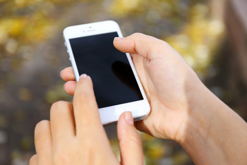 Woman holding smartphone outside