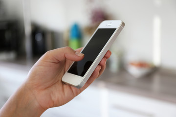 Woman holding smartphone indoors