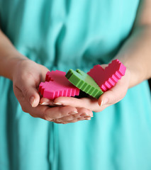 Closeup of plastic puzzle hearts in female hands