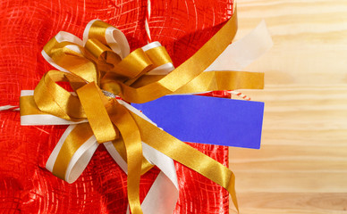 empty blue tag price label with gold ribbon on top of christmas gift box