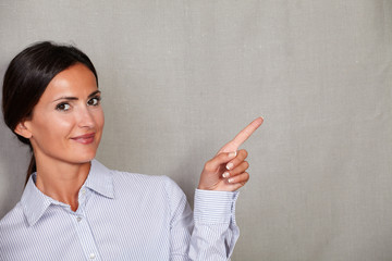 Well-dressed adult lady smiling and pointing