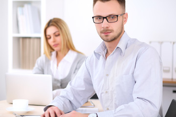 Fototapeta premium Successful businesspeople working at meeting in office. Businessman looking at camera. Start up business concept.