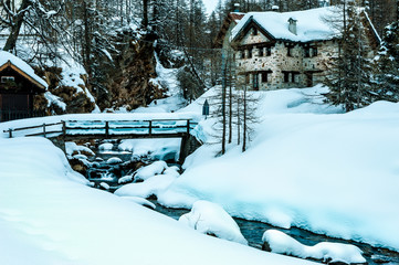 Winter landscape with bridge and traditional house
