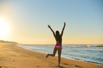 Fototapeta na wymiar Sexy girl running on the beach, in a stylish bikini enjoying summer vacation