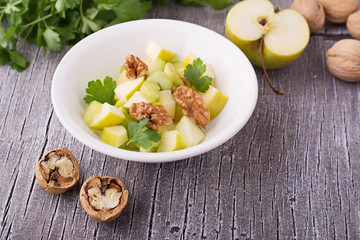 Light fresh spring salad with green apple, stem celery, walnuts