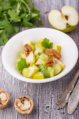 Light fresh spring salad with green apple, stem celery, walnuts