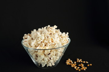 Popcorn in a glass bowl on black background
