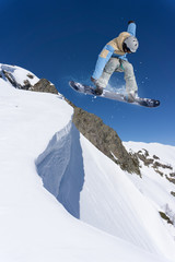 Flying snowboarder on mountains. Extreme sport.