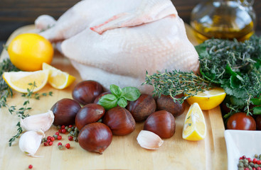 Raw chicken, chestnuts, lemon, herbs and spices. Ingredients for cooking dinner