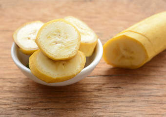 sliced banana in a cup over a table.
