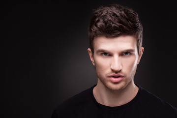 Stylish guy close up portrait on black background