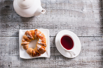 Cup of fruit tea with croissant