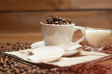 White cup of coffee and milk on wooden surface