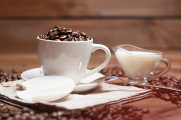 White cup of coffee and milk on wooden surface