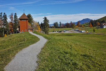 Fototapeta na wymiar Old church and autumn trees near mount Rigi, Alps, Switzerland