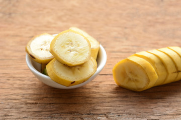 sliced banana in a cup over a table.