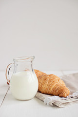 Romantic breakfast with croissant, coffee, milk, honey and jam on the table