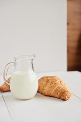Romantic breakfast with croissant, coffee, milk, honey and jam on the table