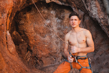 Rock climber holding belay rope against the rock