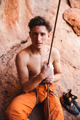 Rock climber holding belay rope against the rock