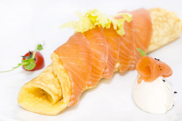 scrambled eggs with cheese and salmon decorated with tomato on white background