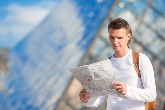 Young tourist man with map in european city outdoors