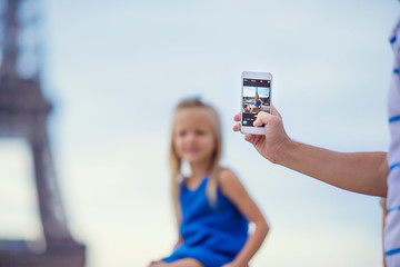 Cute little girl background the Eiffel tower during summer vacation in Paris