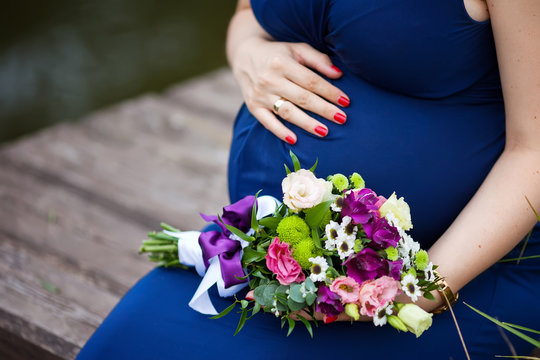 Close-up Image of pregnant woman touching her belly with hands