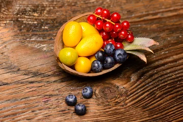 Foto op Plexiglas Exotic fruits in a nutshell on a wooden background © Aurelian Nedelcu