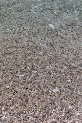 Brown sand under clear water.