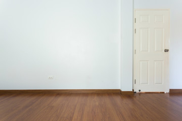 empty room with brown wood laminate floor and white mortar wall