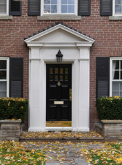 front door of brick house with shutters