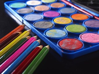 Pallette of water colors and colored pencils