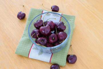 Cherries in glass bowl on wooden table