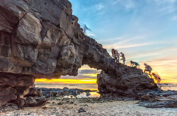 Sunset on giant stone gate skylight regulate marriage makes shimmering, people connect to climb stone gate forming streaks like the ghosts of beautiful photography
