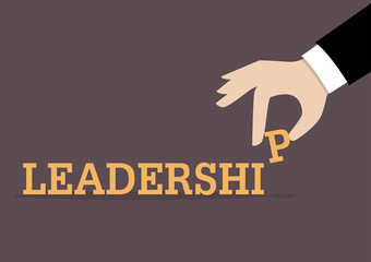 Hand inserts the last alphabet into leadership word