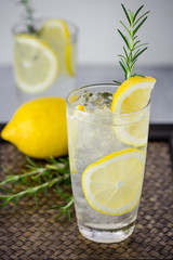 Lemonade with fresh lemon and rosemary in glass