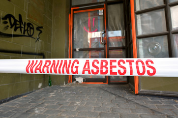 Sign reads: Warning - Asbestos removal in progress