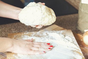 Women hands holding dough and flour smoothes