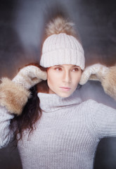 Portrait of brunette woman in warm winter hat.