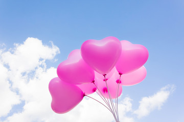 Fototapeta na wymiar Group of lovely pink heart pattern balloons on blue sky