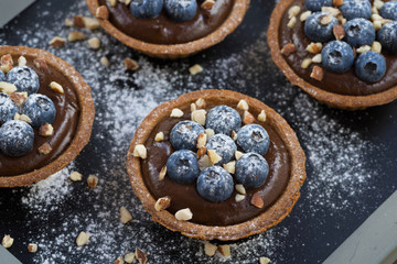 chocolate mousse with fresh blueberries and nuts in tartlets