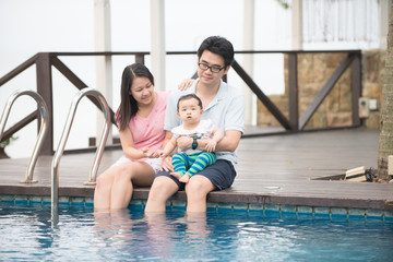 Fototapeta na wymiar asian family having fun at the pool