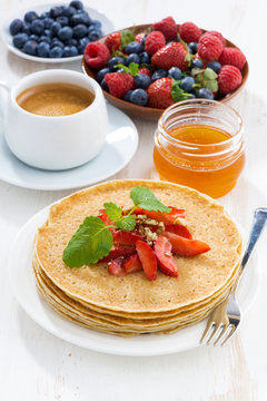 crepes with strawberries and honey for breakfast, vertical