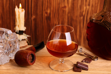 A glass of cognac, chocolate and smoking pipe