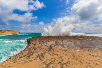 Big wave breaks on a rock with explosion like splashes