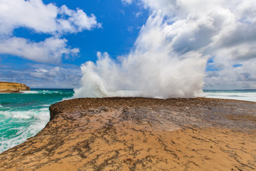 Big wave breaks on a rock with explosion like splashes