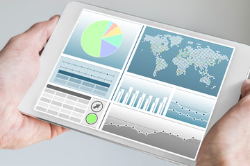Business man holding modern tablet with both hands with business dashboard in neutral color